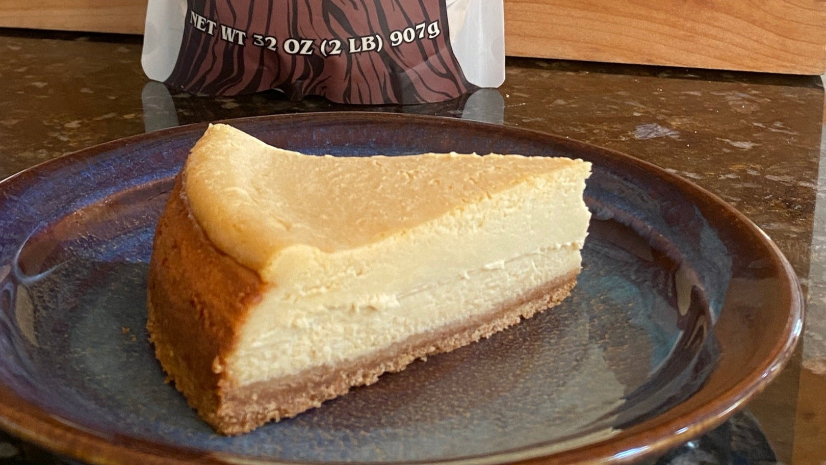Bag of maple sugar from Maple Makers Farm next to a slice of cheesecake on a wooden surface